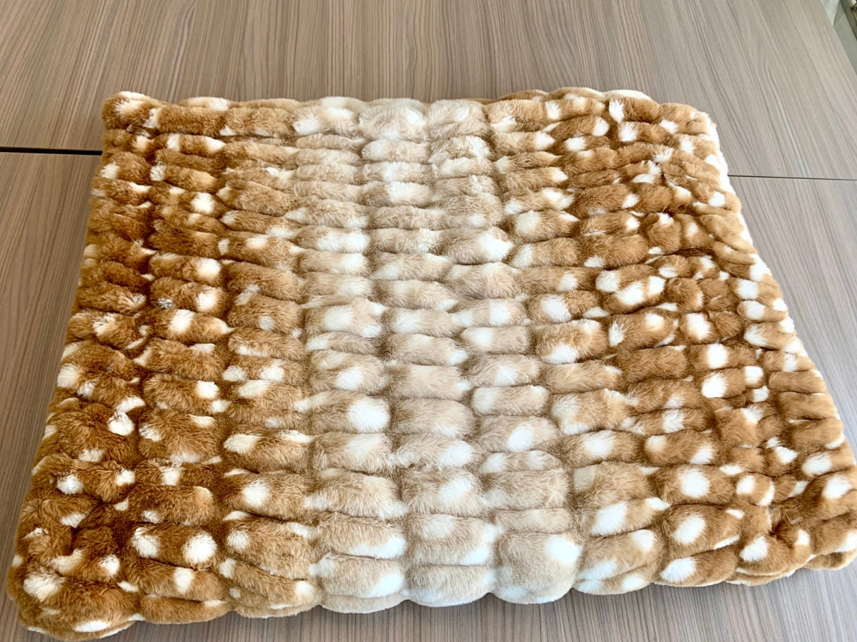 Folded Golden Fawn blanket showing ribbed texture and cream and brown spotted pattern